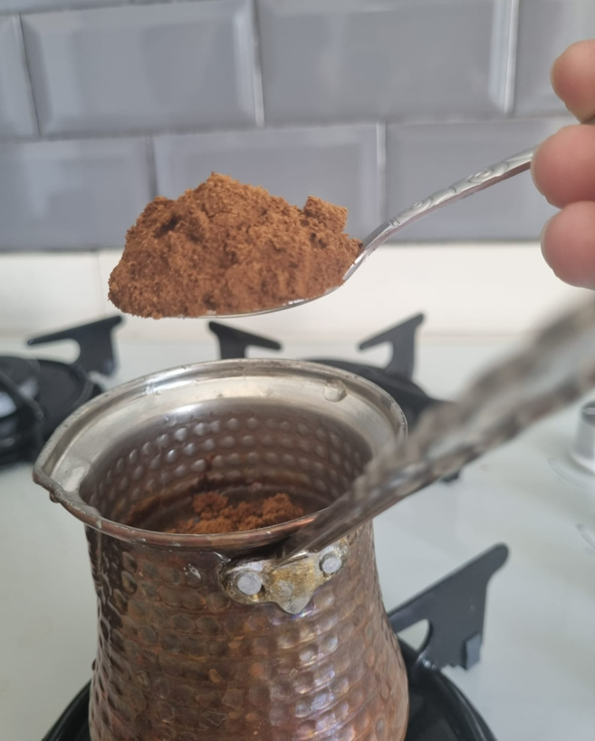 A photo of adding coffee to the coffee pot