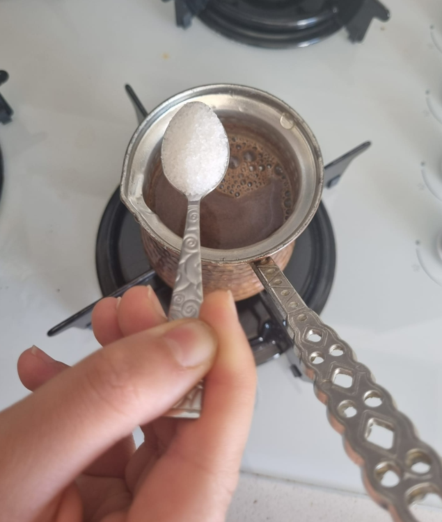 A photo of adding granulated sugar to the coffee pot
